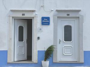 een blauw-wit gebouw met twee deuren en een plant bij Casa Sebastião in Faro