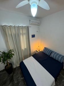 una camera con letto e ventilatore a soffitto di Linda Kitnet mobiliada a São Vicente