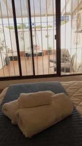 Una toalla puesta en una cama con una ventana grande en Monoambiente céntrico en Montevideo