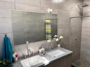 baño con 2 lavabos y espejo grande en Casa excelente (Llano Chico), en Quito