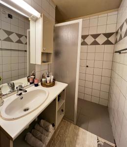 uma casa de banho com um lavatório e um chuveiro em Luxury Service Apartment by Chanya em Ålesund