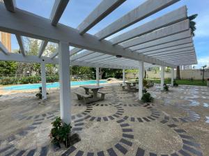 a pavilion with picnic tables and a pool at Cómodo apartamento Vacacional en Margarita 