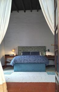 1 dormitorio con 1 cama grande con sábanas y almohadas azules en Casa Jardín de Tiagua, en Tiagua
