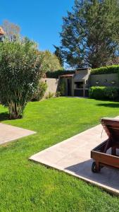 a yard with a house and a bench in the grass at Chacras de Coria Relax in Ciudad Lujan de Cuyo