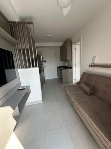a living room with a couch and a kitchen at Laguna 380 - 1607B - Vista Palácio Tangará in São Paulo