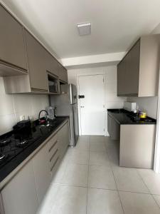 a kitchen with white cabinets and black counter tops at Laguna 380 - 1607B - Vista Palácio Tangará in São Paulo +14 photos