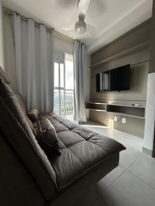 a living room with a couch and a large window at Laguna 380 - 1607B - Vista Palácio Tangará in São Paulo
