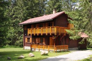 une cabane en rondins avec une véranda et une terrasse dans l'établissement Chata Pribisko 651, à Zuberec