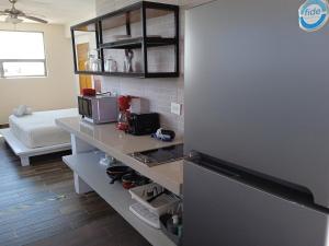 a kitchen with a refrigerator and a living room at Moon 4 in Puerto Morelos