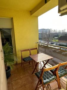 een patio met een tafel en stoelen op een balkon bij CAPITAL APARTMAN VIROVITICA in Virovitica