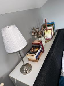 a bedside table with a lamp and books on it at CAPITAL APARTMAN VIROVITICA in Virovitica