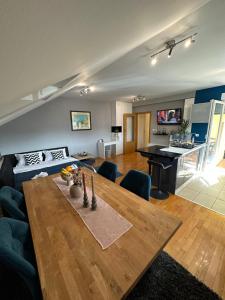uma sala de estar com uma mesa de madeira e uma cozinha em CAPITAL APARTMAN VIROVITICA em Virovitica