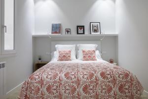 1 dormitorio blanco con 1 cama grande y 2 almohadas en Zurriola Zinema by FeelFree Rentals, en San Sebastián