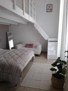 a white bedroom with a bed and a couch at Casa Cavour in Livorno