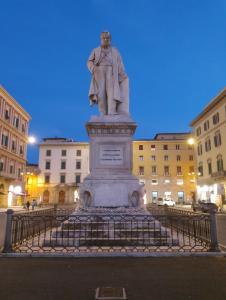 una estatua de un hombre en un pedestal en una ciudad en Casa Cavour, en Livorno