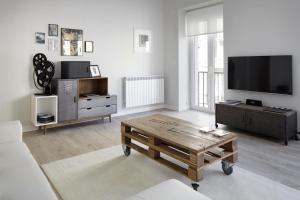sala de estar con TV y mesa de centro en Zurriola Zinema by FeelFree Rentals, en San Sebastián