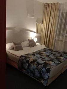 um quarto com uma cama grande e um cobertor em ApartHotel Bielik B-04 em Międzyzdroje