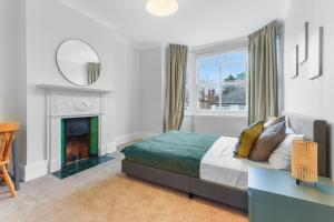 um quarto com uma cama e uma lareira em Windsor House near the Park em Hendon