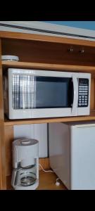a microwave sitting on a shelf in a kitchen at Maggie's Cozy Corner in Wimauma