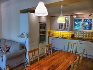 cocina y comedor con mesa y sofá en Family Cottage, en Gárdony