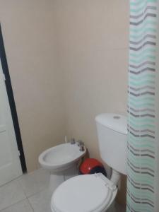 a white bathroom with a toilet and a sink at La Aldea in Rodeo de la Cruz +9 photos