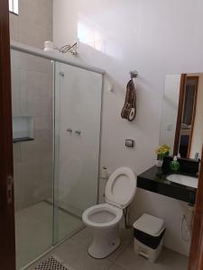 ein Bad mit einer Dusche, einem WC und einem Waschbecken in der Unterkunft Casa Flor in São João Batista do Glória