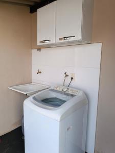 eine Waschmaschine in einem Zimmer mit Waschbecken in der Unterkunft Casa Flor in São João Batista do Glória