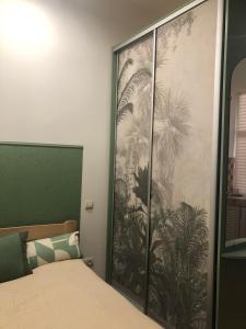 ein Schlafzimmer mit einem großen Palmenmilch in der Unterkunft Apartment near Armenian Cathedral in Lwiw