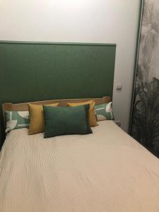 Schlafzimmer mit einem Bett mit einem grünen Kopfteil in der Unterkunft Apartment near Armenian Cathedral in Lwiw
