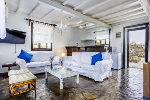a living room with two white couches and a table at Elli Cottage in Skopelos Town