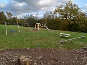 um parque com um parque infantil com um banco e um escorrega em BELLA VITA Les Terrasses de Malmédy Triplex 264 em Malmedy