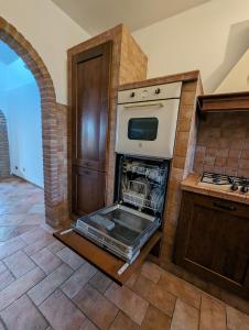 eine Küche mit Backofen und offener Tür in der Unterkunft La Villetta del Gelso bianco in Aprilia