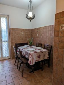 ein Esszimmer mit einem Tisch, Stühlen und einem Kronleuchter in der Unterkunft La Villetta del Gelso bianco in Aprilia