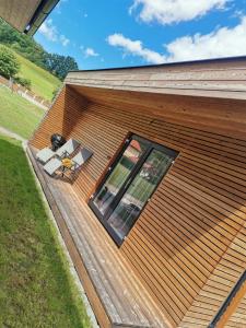 a wooden house with a window and a patio at Minidomeček Páteček in Klatovy