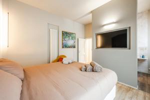 a bedroom with a large bed with a flat screen tv at Urban Cottage [Free Parking - Private Garden] in Bologna