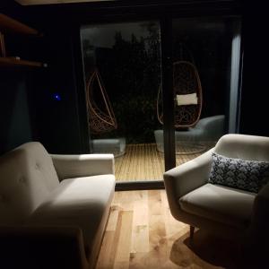 un soggiorno con 2 sedie e una vista su un patio di Recently extended garden apartment near JR and Oxford a Oxford