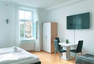 a bedroom with a bed and a table and a tv at Quad Room In Keplerplatz in Vienna