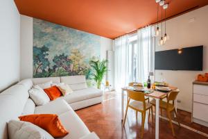 sala de estar con sofá blanco y mesa en Urban Cottage [Free Parking - Private Garden], en Bolonia