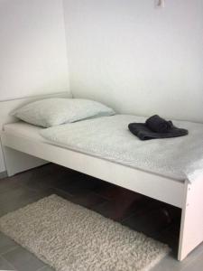 uma cama branca com uma toalha preta em Messezimmer nahe Flughafen direkte Verbindung Messe em Langenhagen