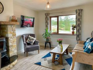 a living room with a couch and a fireplace at The Cosy Farm Cottage, Donegal in Inver