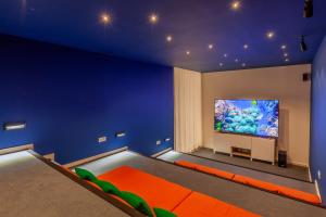 ポルトにあるSavvy Signature Apartmentsの壁に大型テレビが掛かっている青い部屋