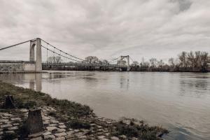 eine Brücke über einen Wasserkörper mit wolkigem Himmel in der Unterkunft Les reflets de Loire in Chalonnes-sur-Loire + 1 Foto