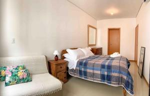 1 dormitorio con 1 cama y 1 sofá en Apto De Praia • c/ Yoga • 500m do Mar, en Florianópolis