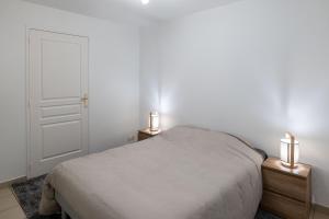 ein Schlafzimmer mit einem Bett und zwei Lampen an Nachttischen in der Unterkunft Les reflets de Loire in Chalonnes-sur-Loire