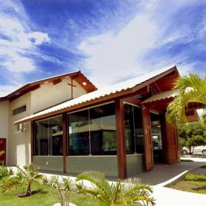 a building with glass doors and a palm tree at Eventos Villa Garden in Aracaju