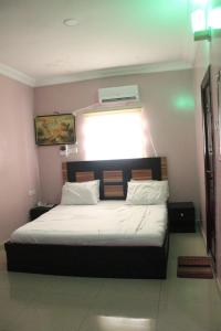 a bedroom with a large bed with a window at Rocket Room Hotel & Suites Limited in Port Harcourt