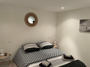 een slaapkamer met een bed en een spiegel aan de muur bij Chez Tony et Laurie in Montbrun-des-Corbières