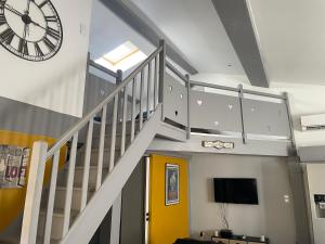 een trap met een klok en een gele deur bij Chez Tony et Laurie in Montbrun-des-Corbières