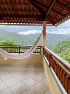einen Balkon mit einer Hängematte und Bergblick in der Unterkunft Casa de Campo Domingos Martins in Domingos Martins