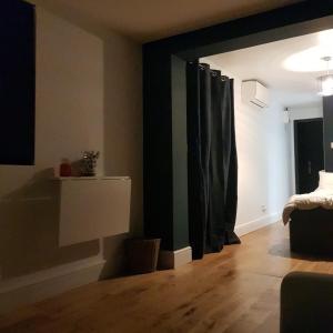 a bedroom with black curtains and a wooden floor at Modern 1-bed apartment, plus parking, near Oxford and the JR in Oxford
